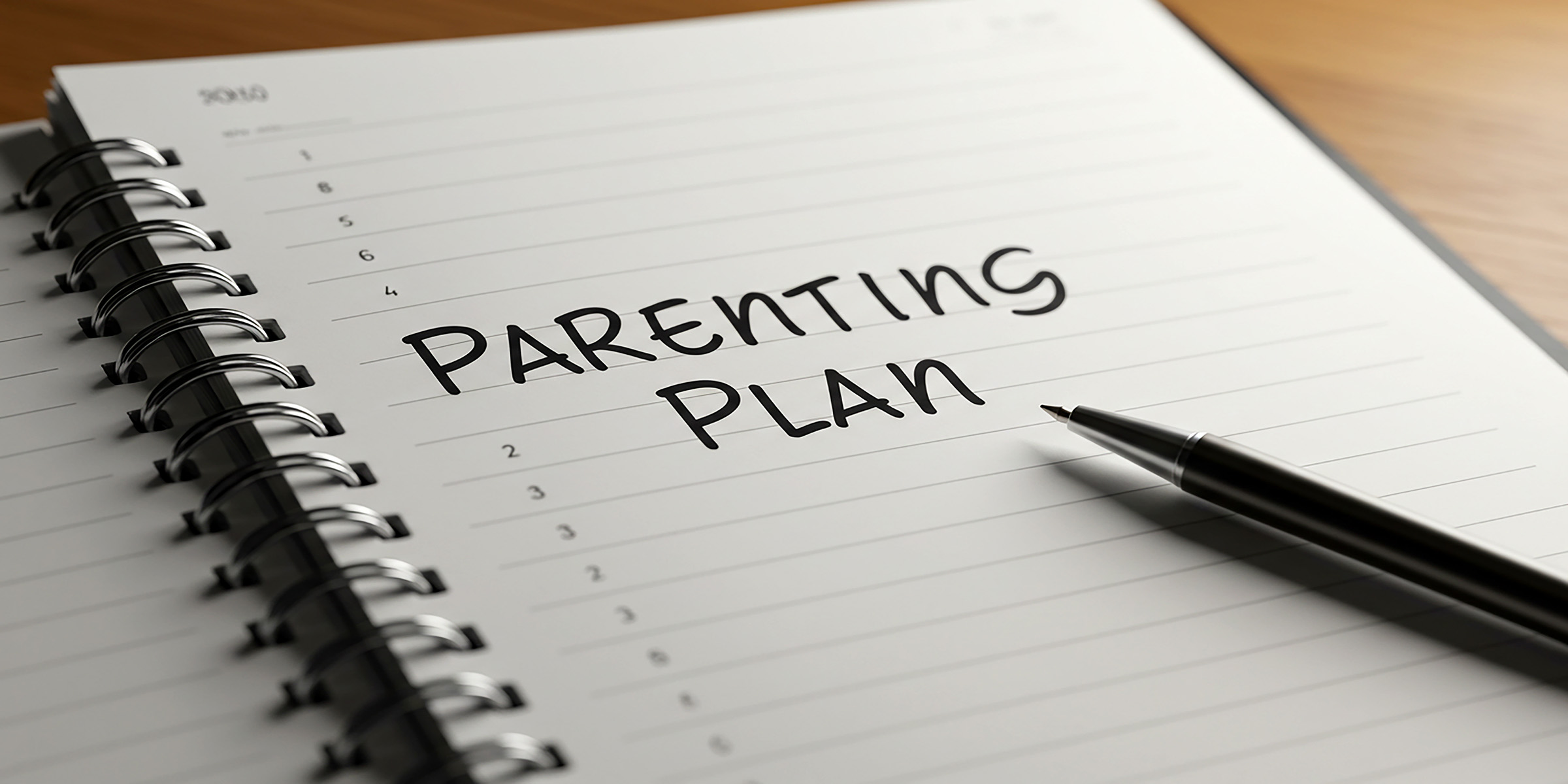 The words "Parenting Plan" written on a white notebook.