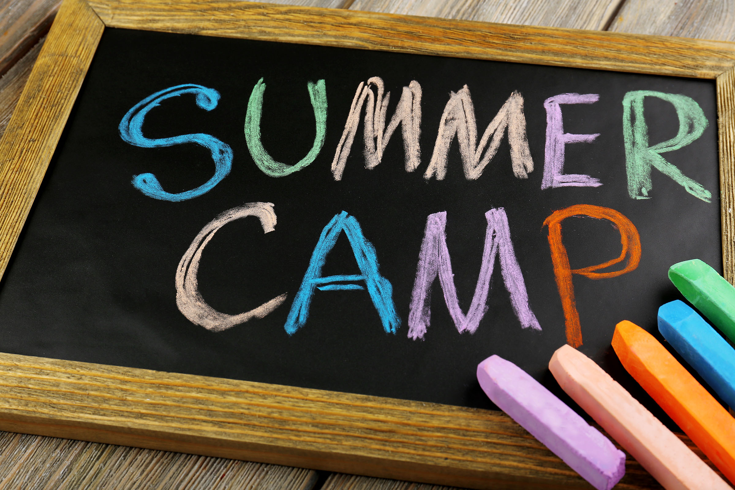 A chalk board with "Summer Camp" written in chalk.