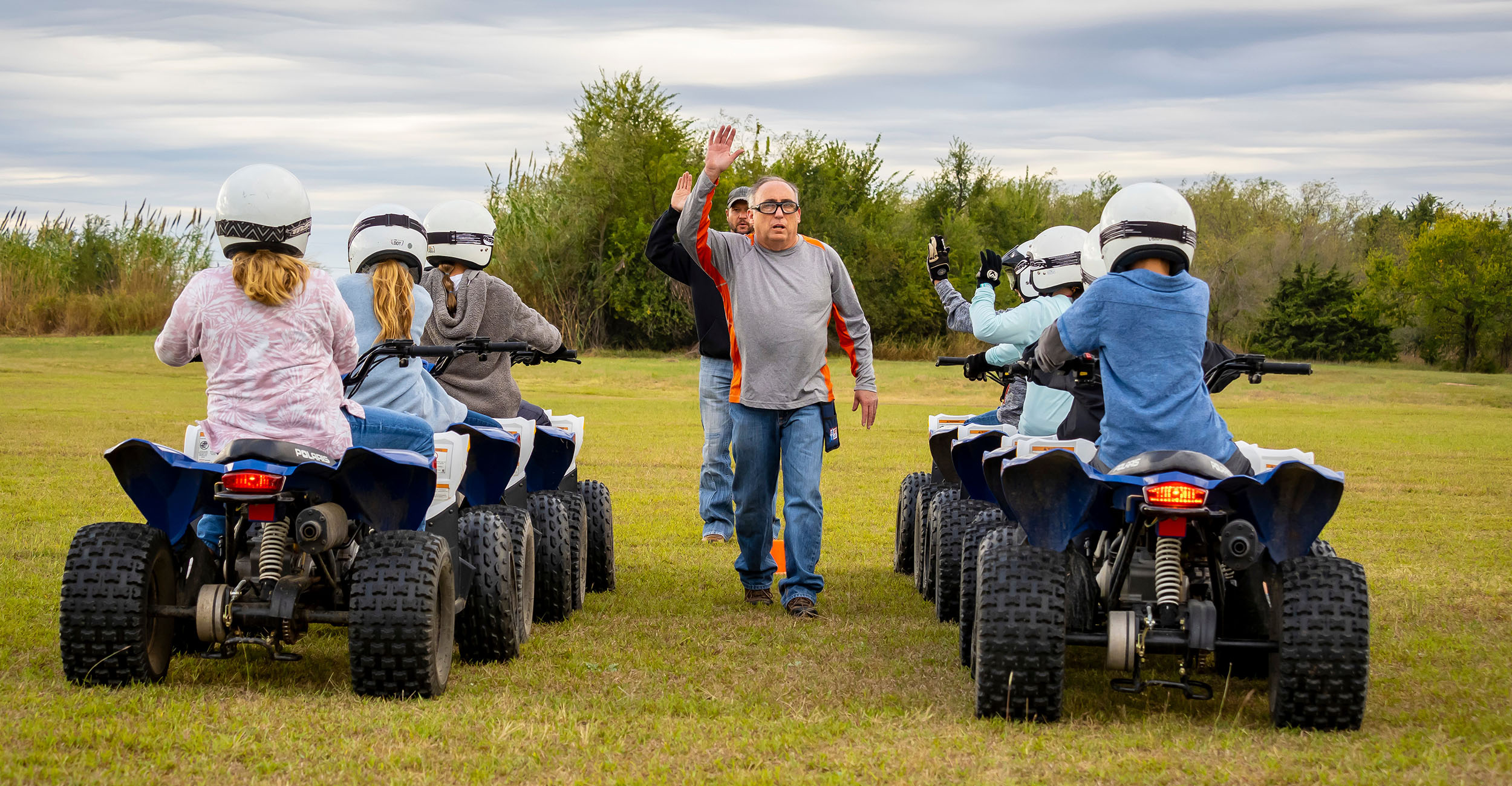 Students riding ATVs learn hand signals used in the safety class.