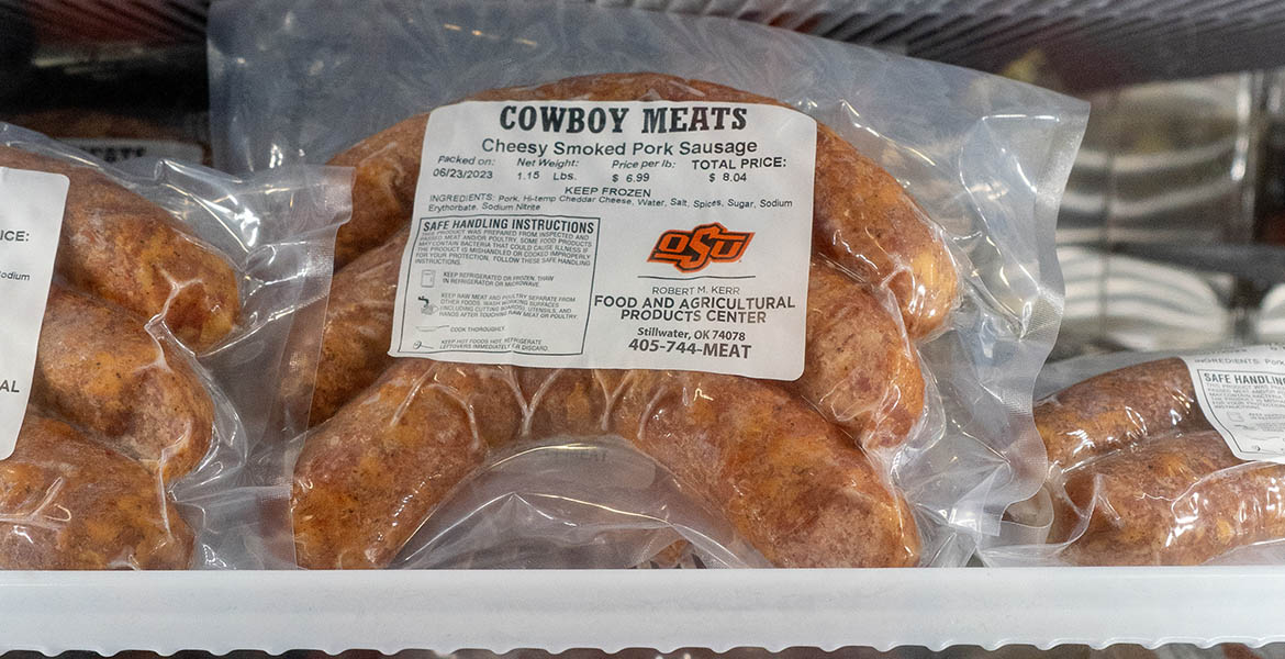 frozen, packaged sausages in a freezer, labeled Cowboy Meats