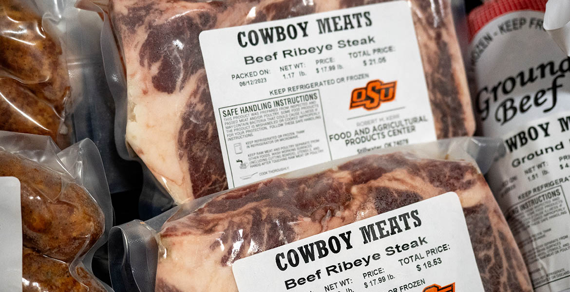 frozen, packaged beef ribeye steaks in a freezer, labeled Cowboy Meats