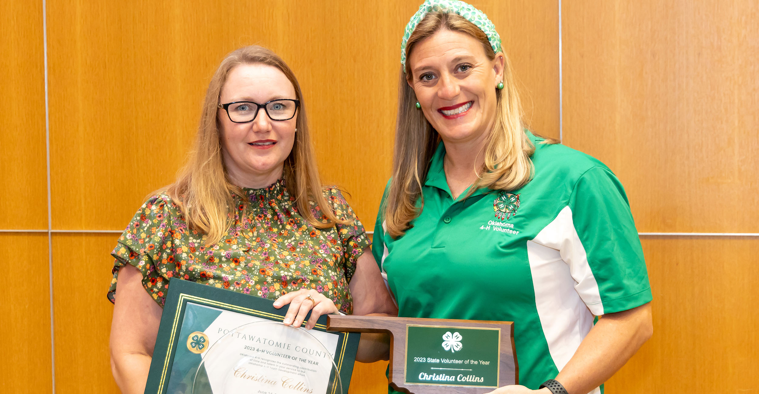 Two women holding a plaque and certificate.