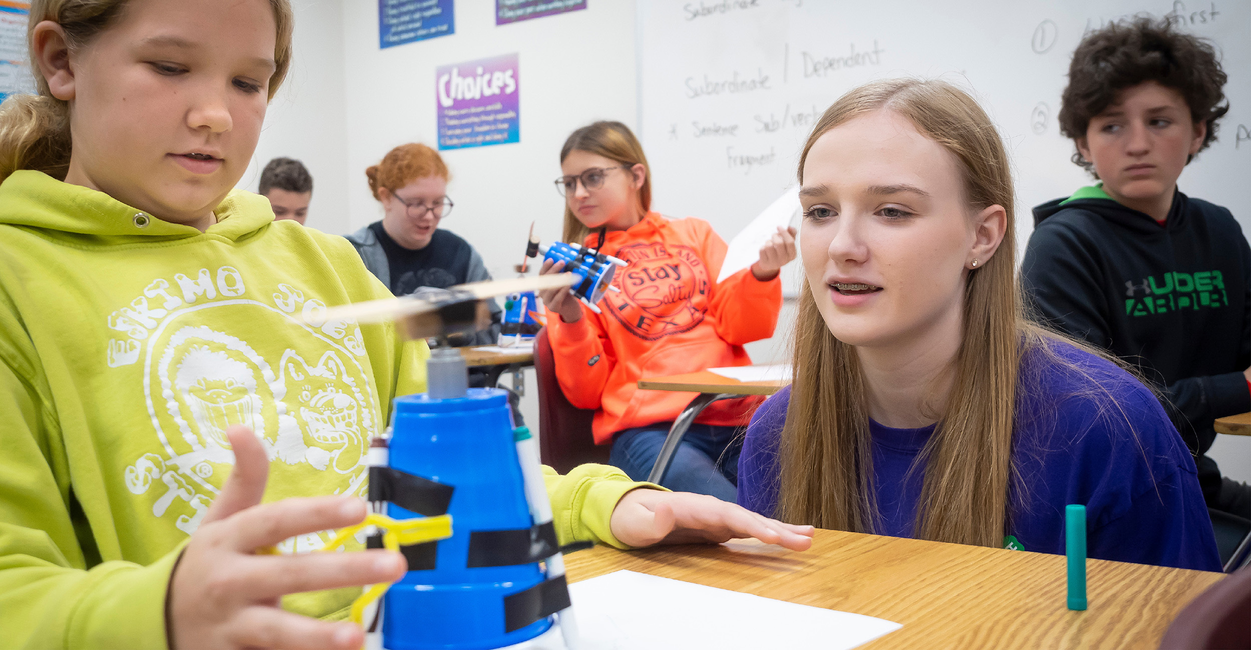 Girl working with student on STEM project.