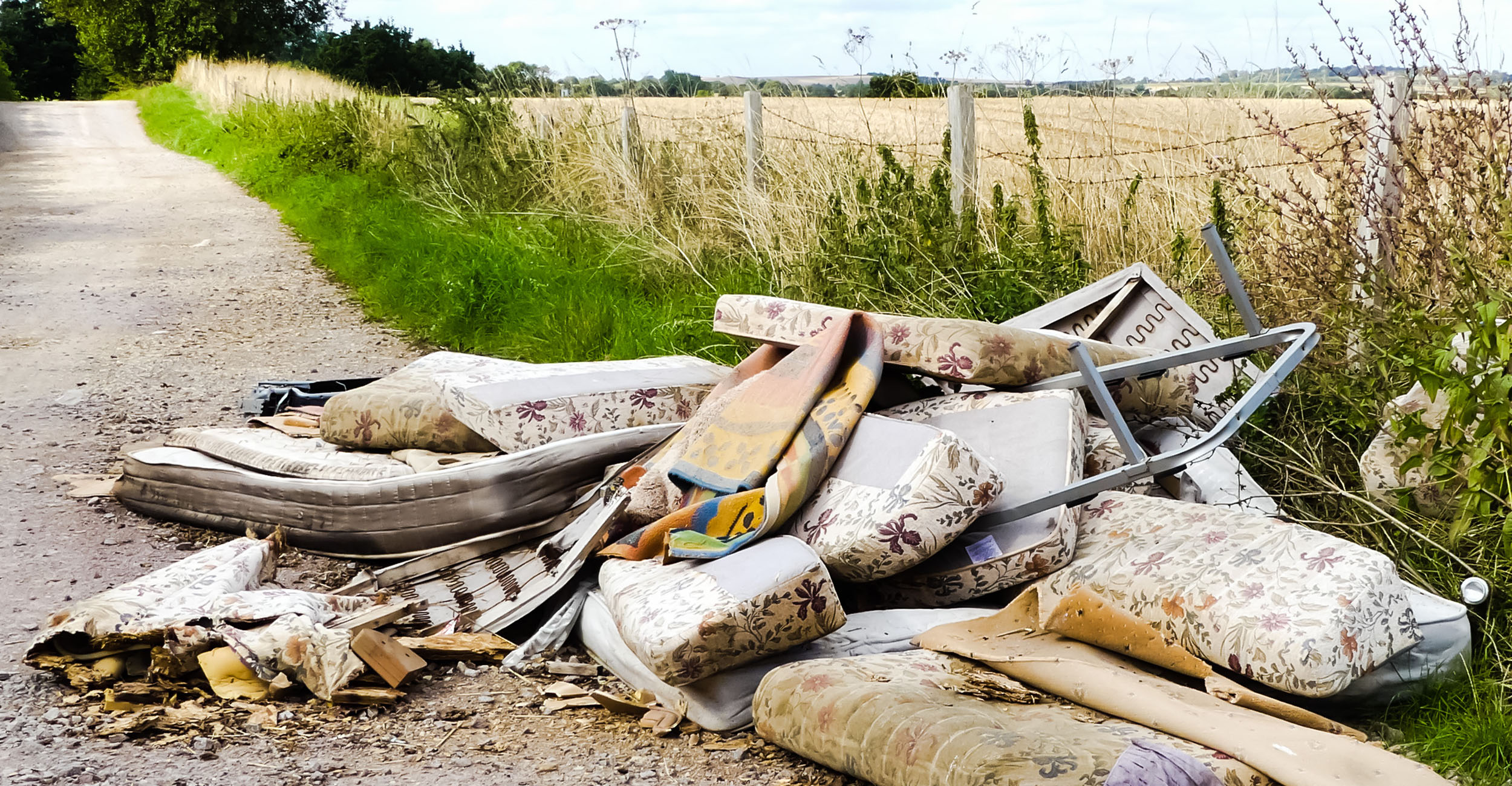 Pile of trash along a country road.