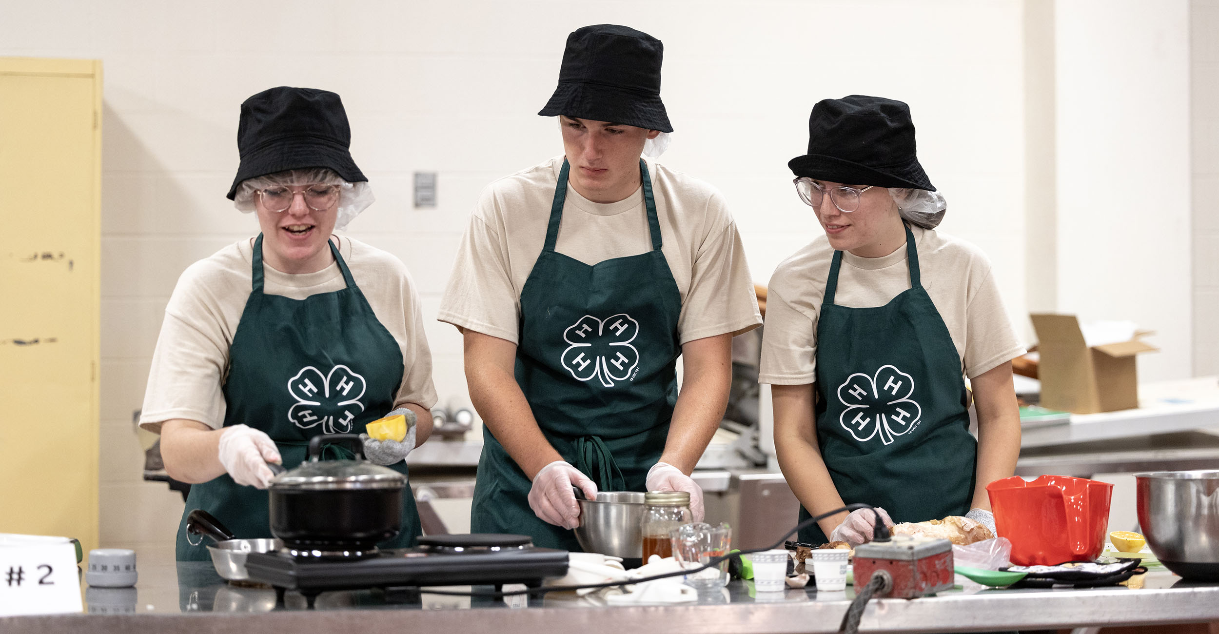 Three 4-H members preparing a dish at the 4-H Food Showdown.