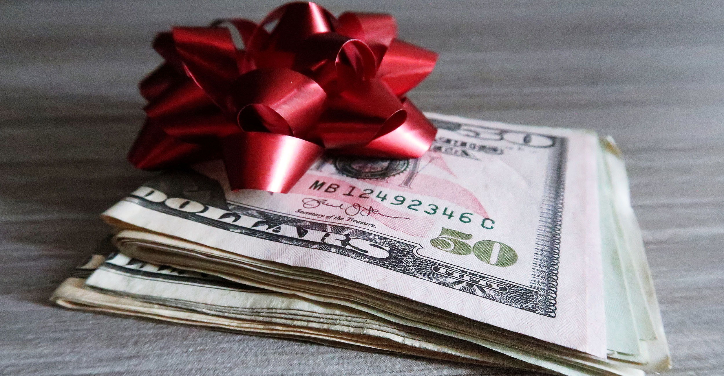 Paper money with a holiday bow on top.