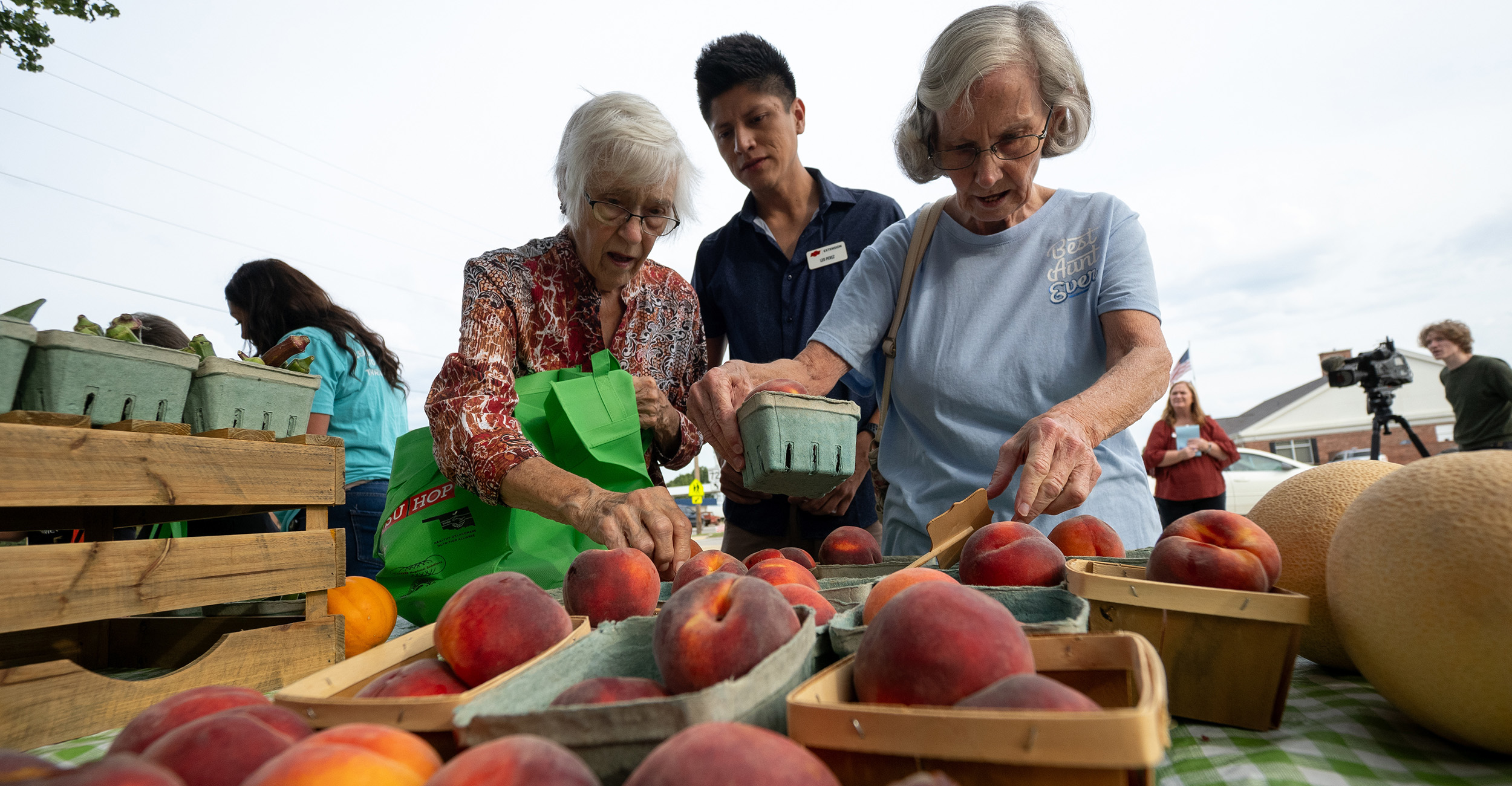 People selecting fresh produce at a farmers market.