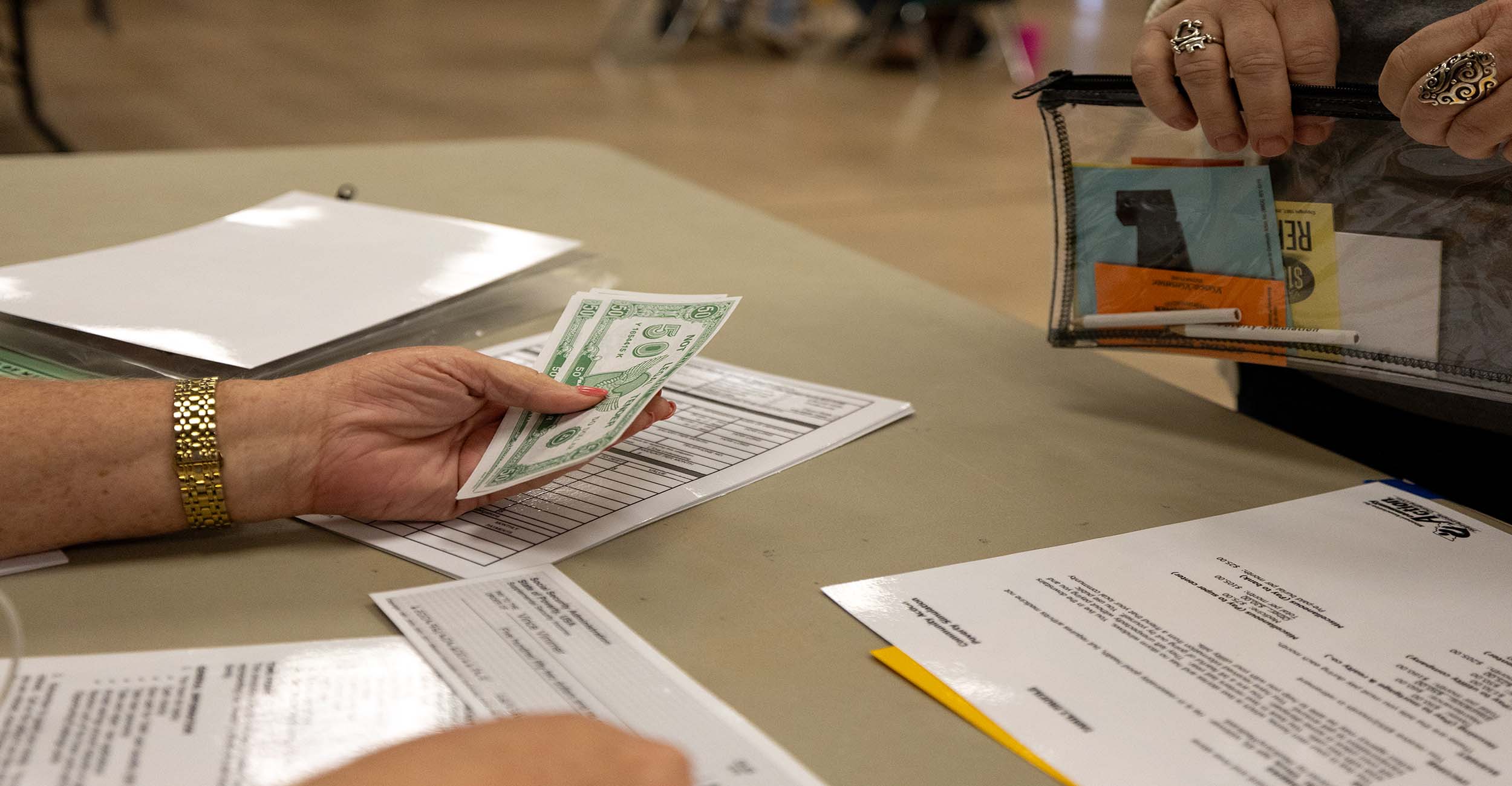 Participants swap fake dollar bills during an OSU Extension simulation.