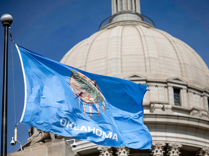 The Oklahoma flag in front of capital building.