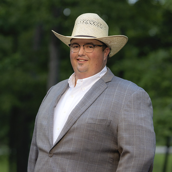 Spencer McGuire wearing a suite and straw hat.