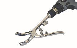 Silver metal pliers with a spring attached, connected to a drill and used as a drill bit.