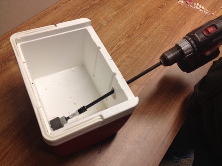 A drilling putting a hole in a cooler.