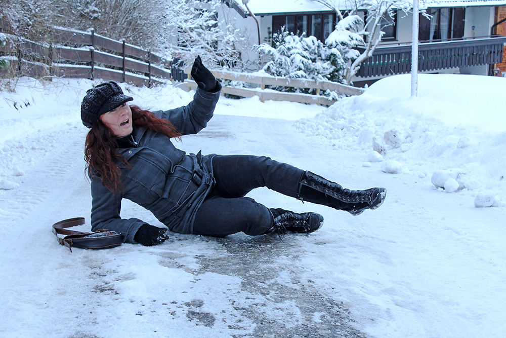 Woman laying on the ground after slipping on the ice.