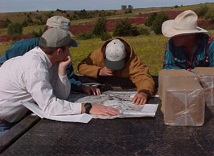 Four individuals reviewing a map. Four individuals reviewing a map.
