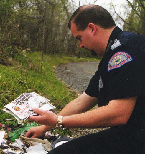 A police officer picking up litter.