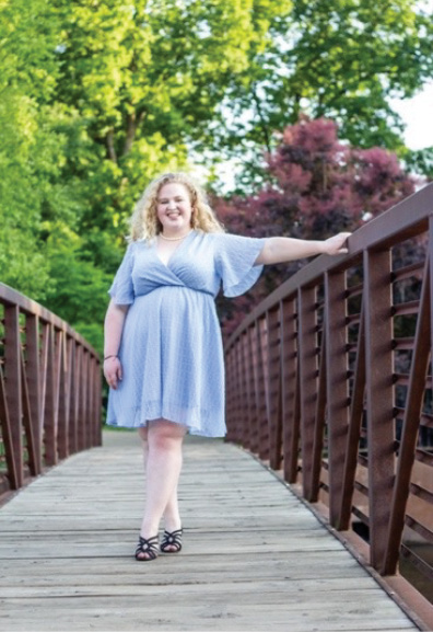 A woman with blonde hair and a blue dress on a bridge.