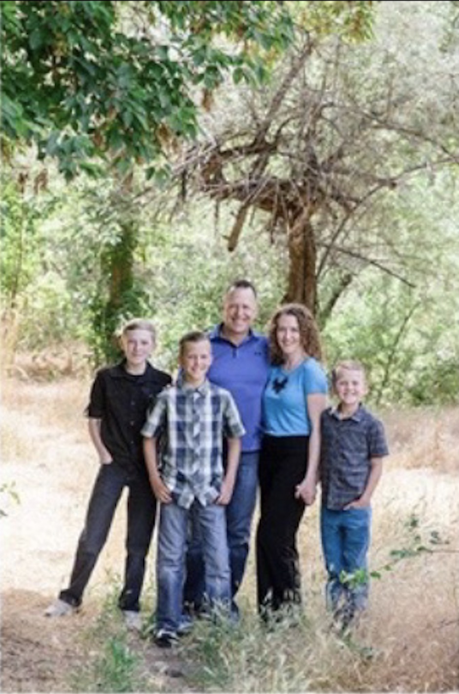 A family wearing blue under a tree, posing for a photo to demonstrate correct exposure.