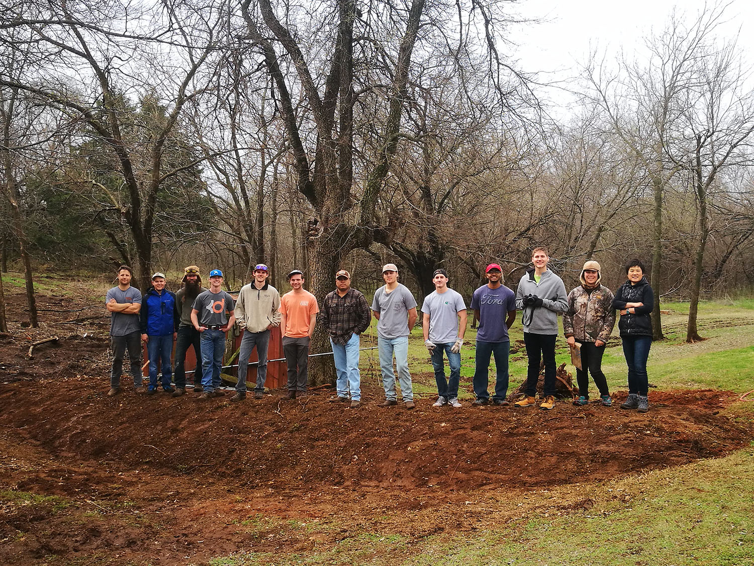 Students and teacher standing on the Hügelkiltur Students and teacher standing on the Hügelkiltur