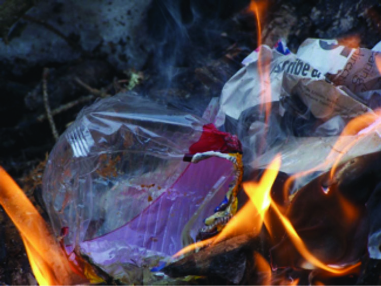 Burning plastics and other materials in an open fire