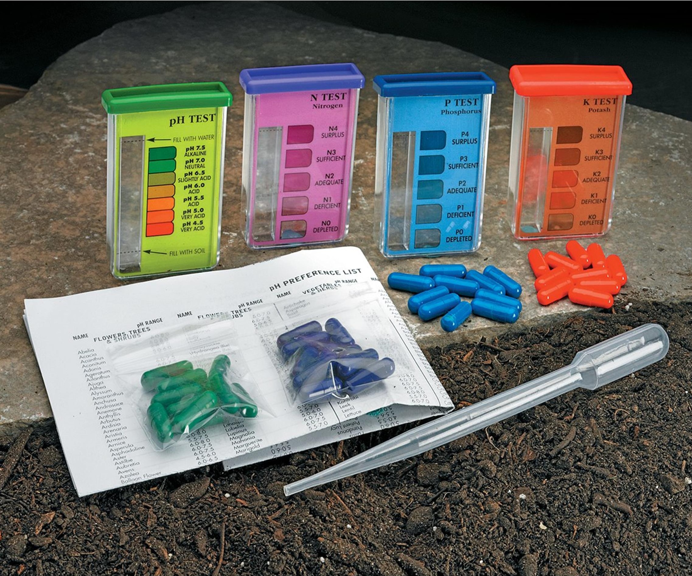 Four soil testing kits. Starting from the left, there is a green Ph test , a purple N test, a blue P test and an orange R test.Sitting in front of the tests are green, dark blue, light blue and orange pill-like containers and a dropper.