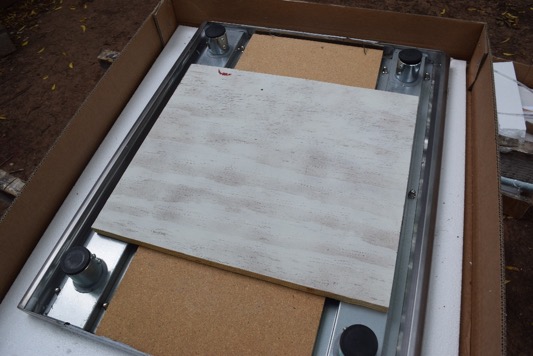 Scrap plywood is placed on the table's top.