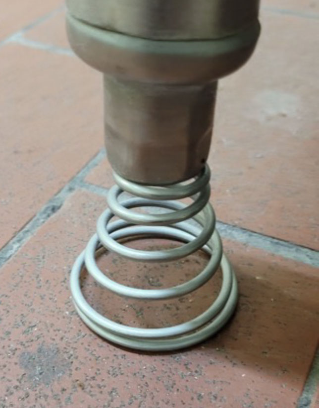 Conical spring supporting table leg.