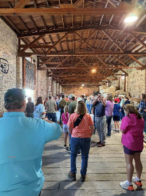 A group of people standing in an open space inside a warehouse.