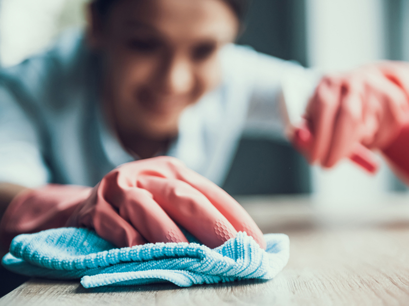 Woman cleaning wood table.