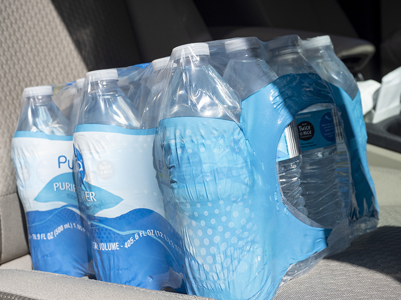A case of bottled waters sitting in a car seat. 