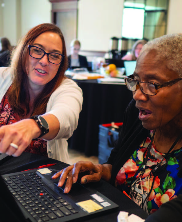 Two women working on a computer.