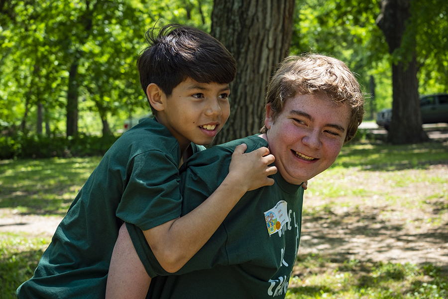 Two children in green shirts playing outside.