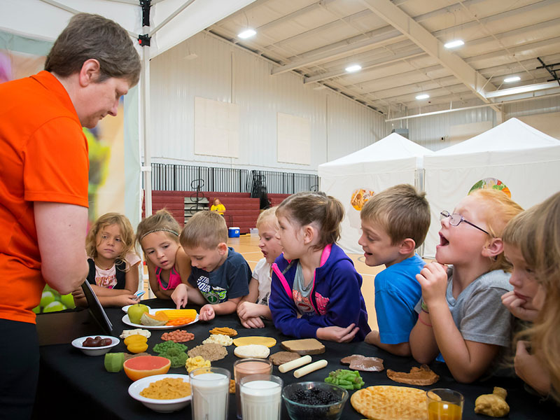 A person showing food to students.