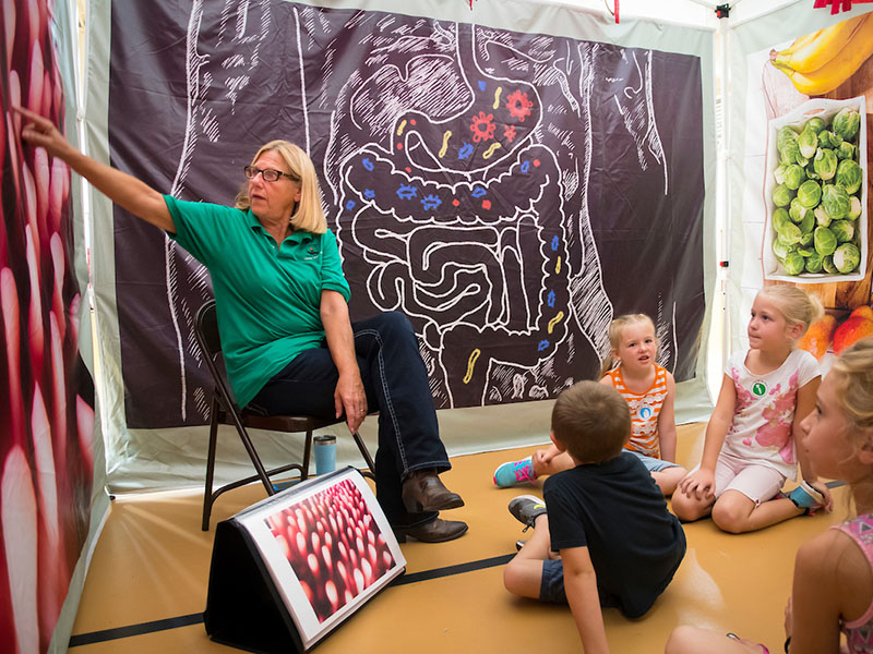A woman pointing at a picture of intestines for a group of students.