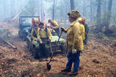 A group of people standing in yellow firefighter jackets. A group of people standing in yellow firefighter jackets.