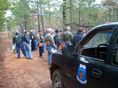 People standing at the front of a truck. People standing at the front of a truck.