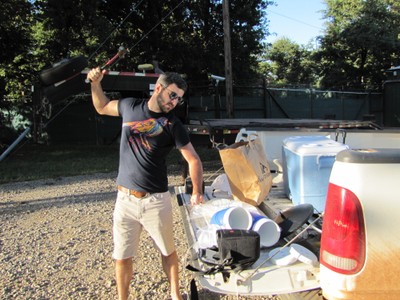 A man using a hammer to crush dry ice on the back of a truck bed. A man using a hammer to crush dry ice on the back of a truck bed.