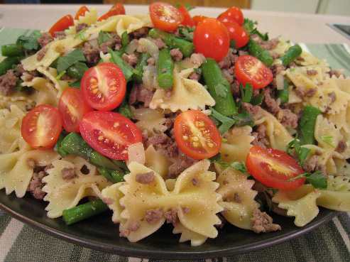Beef and asparagus pasta toss served on a plate.