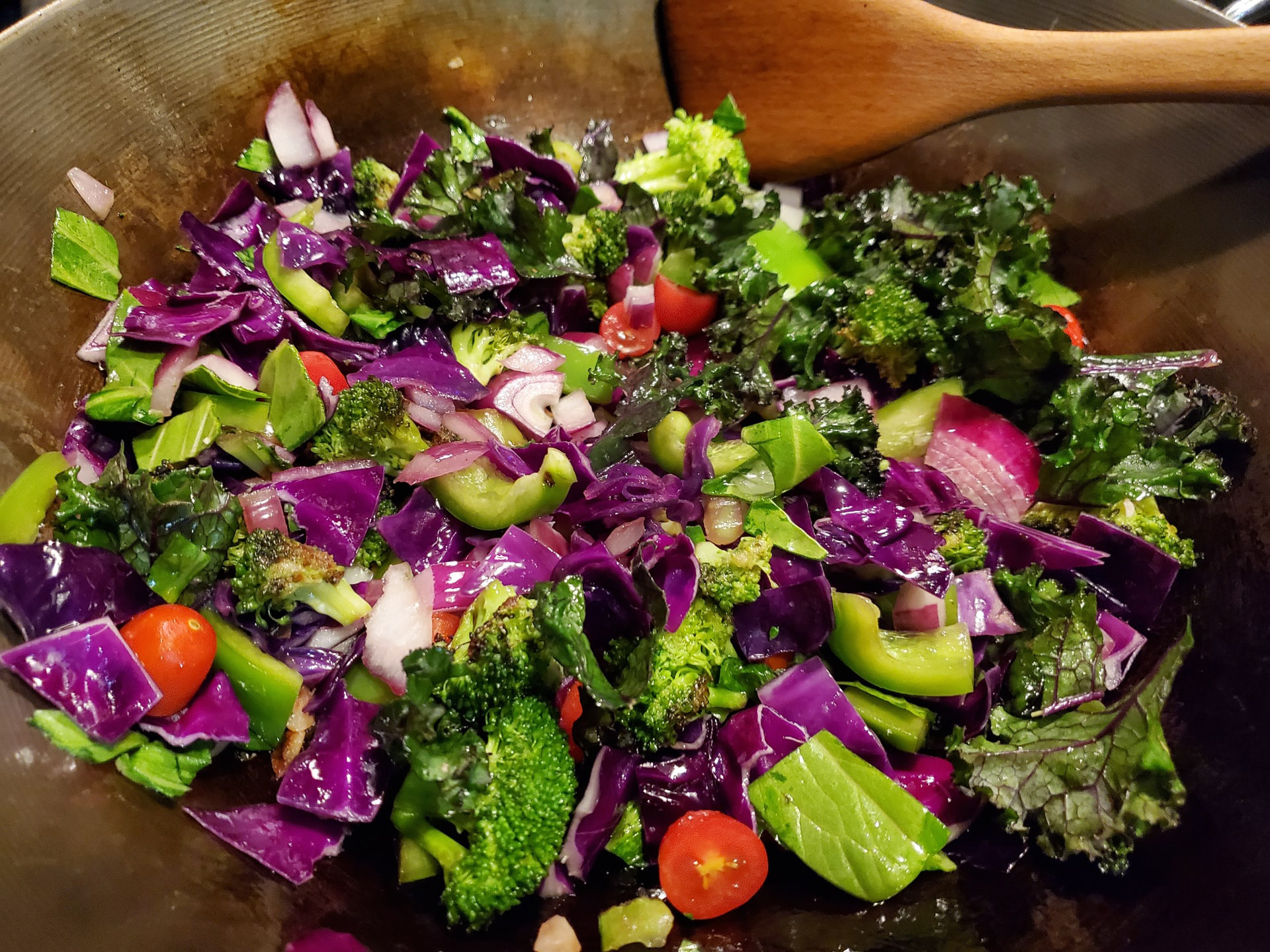 A broccoli salad with onions and tomatoes.