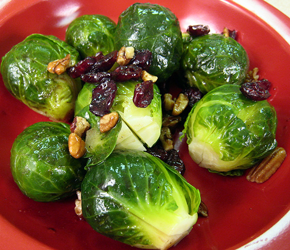Brussels sprouts with toasted pecans and dried cranberries on a plate.