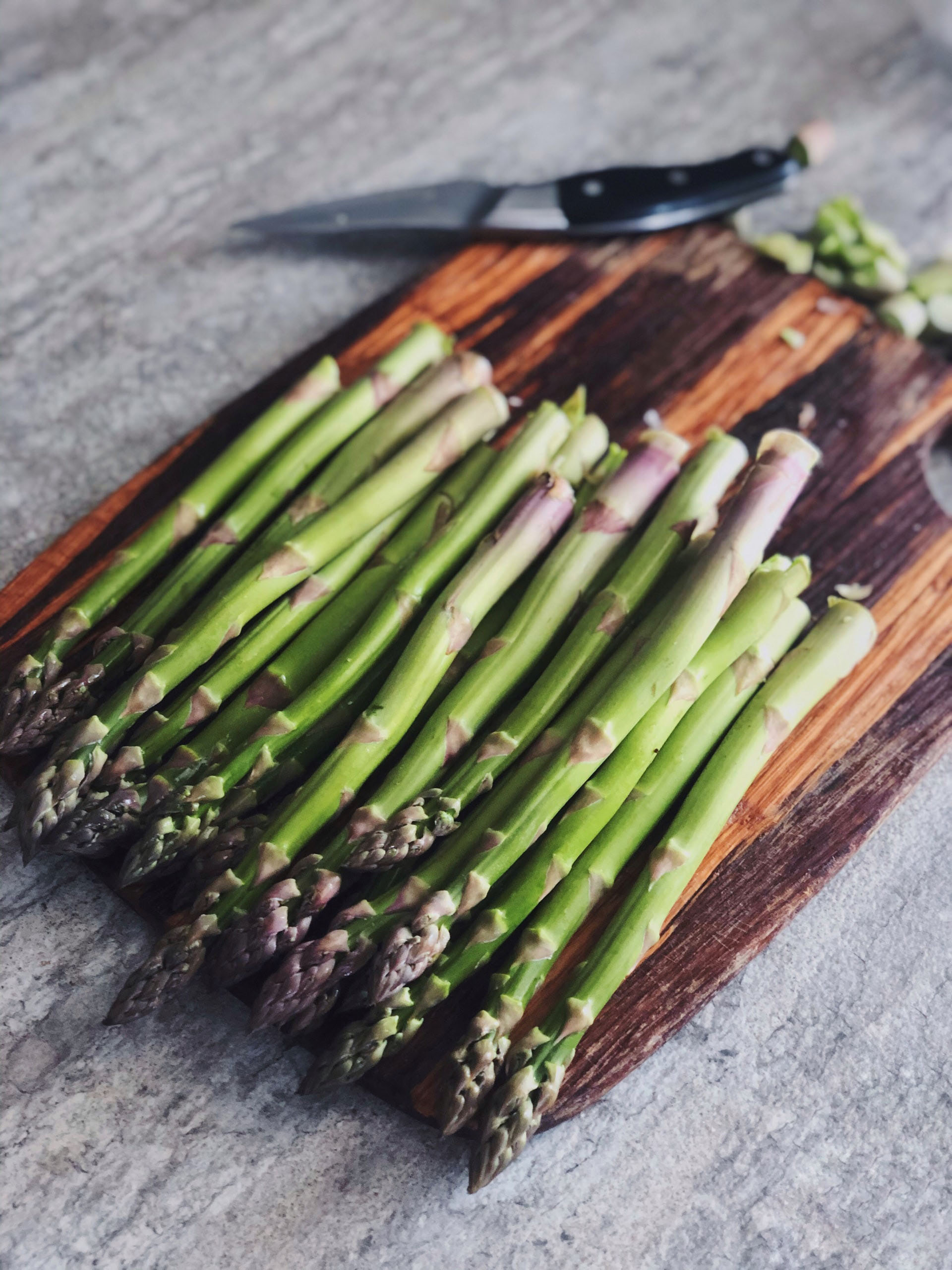 Asparagus on a wooden cutting board.