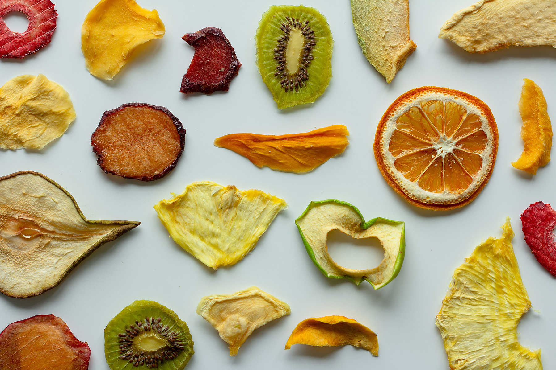 Dried fruits laid out across a white background. 