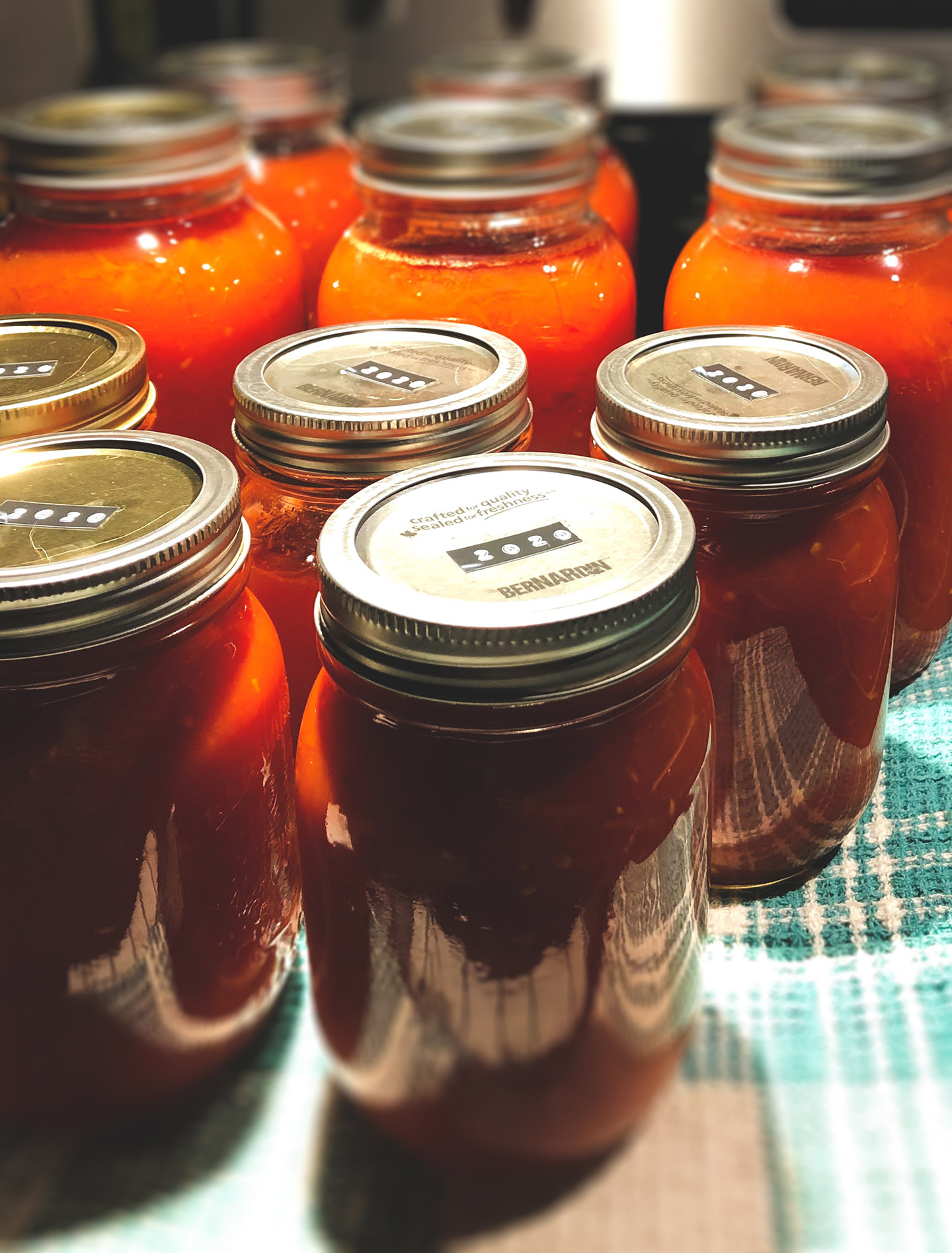 Photo of canned jars with red sauce on them.