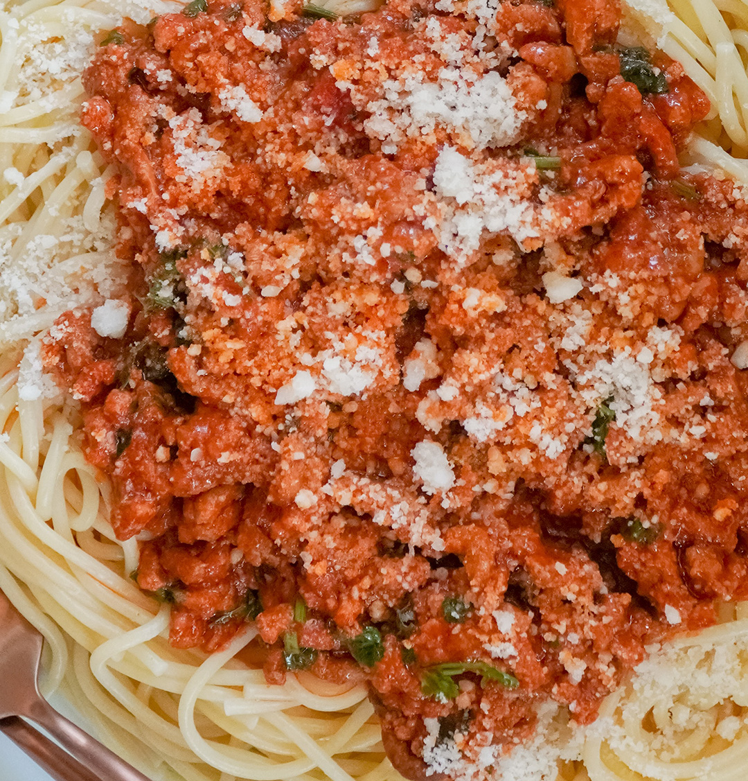 Close up photo of italian tomato sauce over pasta with parmasan cheese. 