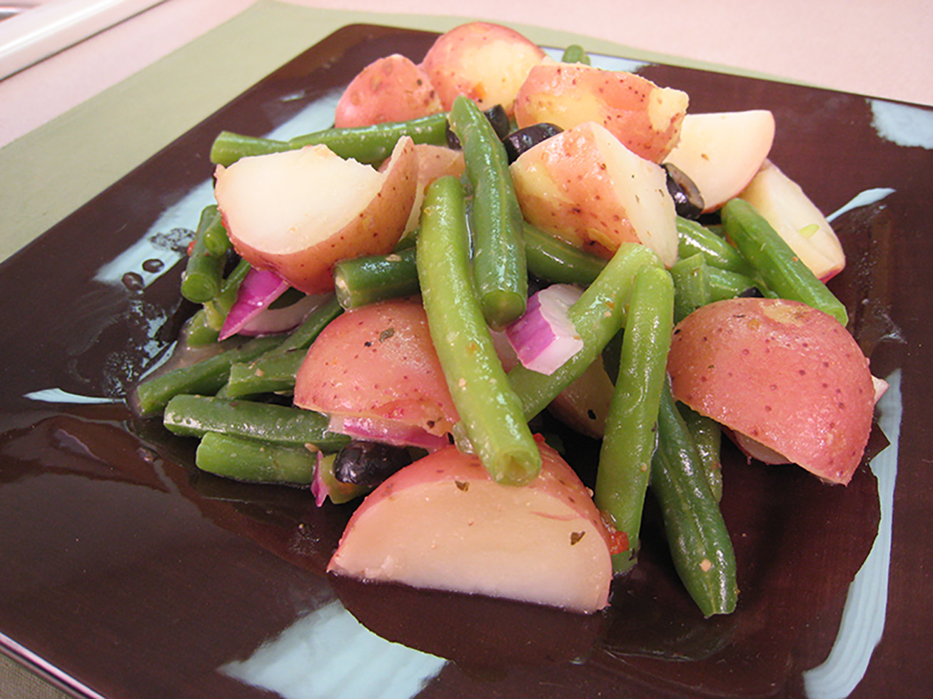 New potato and green bean salad served on a plate.