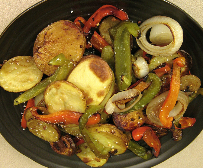 Roasted potatoes, peppers and onions on a plate. 