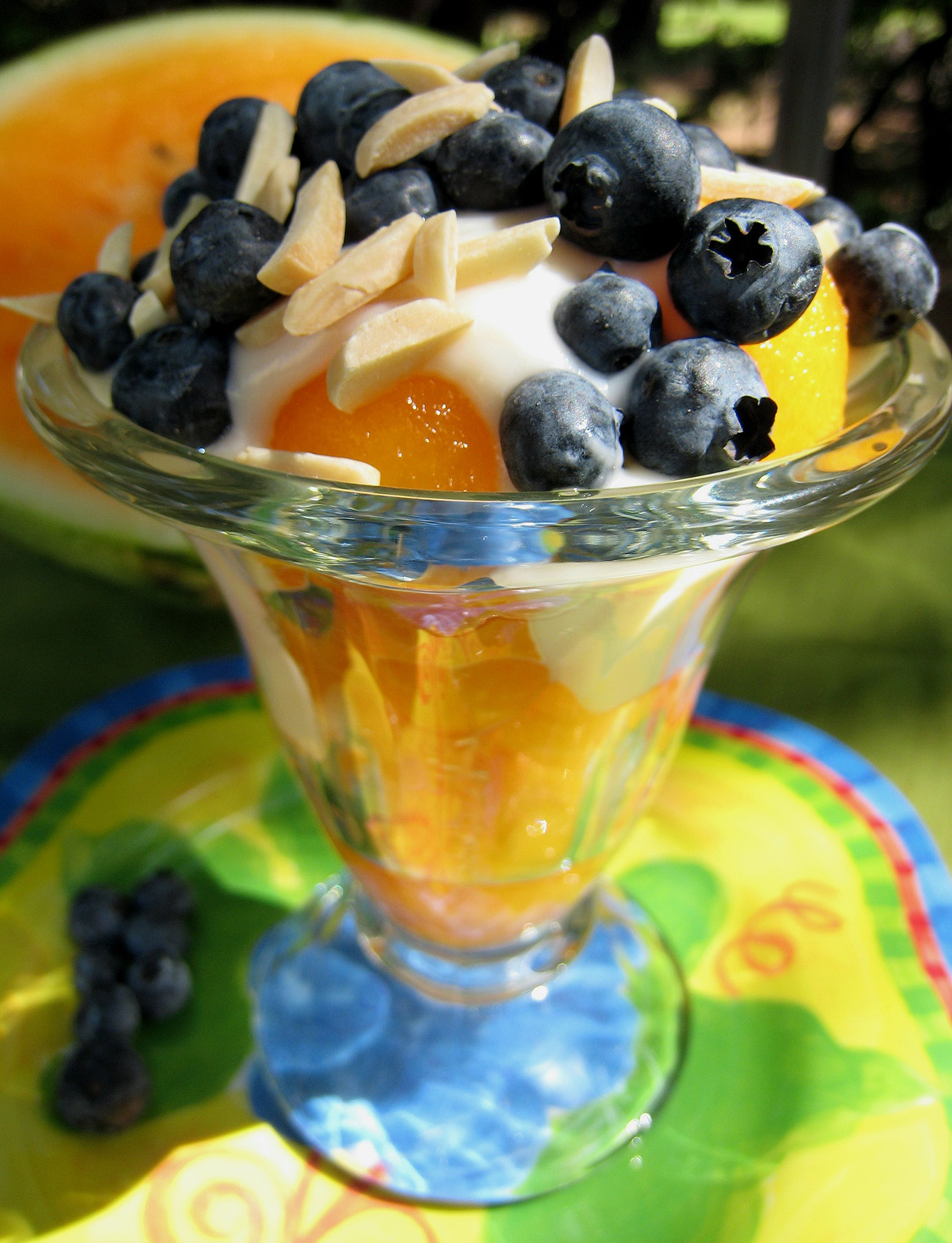 Watermelon sundaes in a glass with almonds and blueberries on top. 