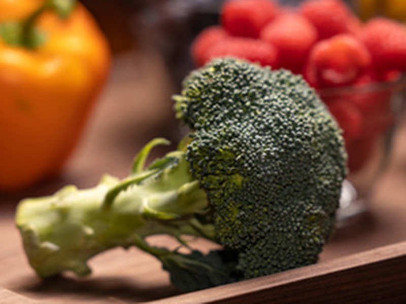 A head of broccoli on a platter of vegetables.