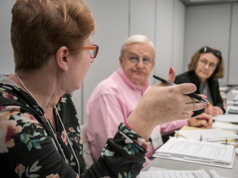 A group of older indviuals looking at one another.