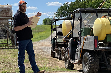 Instructor by a farm vehicle