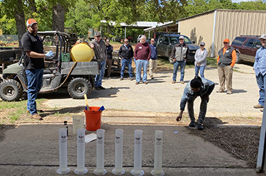 Outside instrujctor by a vehicle and students